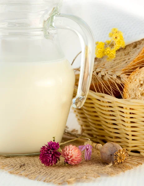 Caraffa con latte, pane e fiori selvatici — Foto Stock