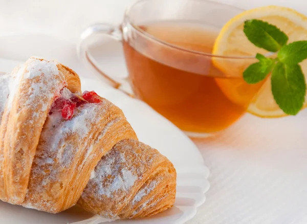 stock image Croissant with jam and tea with a lemon