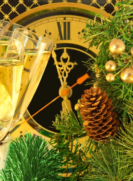 Різдвяна листівка. Окуляри шампанського напередодні Нового року проти старовинного настінного годинника — стокове фото
