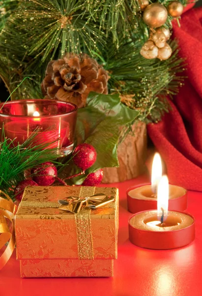 Χριστουγεννιάτικη κάρτα. σαμπάνια, ένα κλαδί από ένα δέντρο-γούνα και ένα κερί σε κόκκινο φόντο — Φωτογραφία Αρχείου