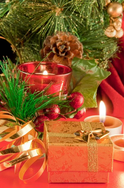 Tarjeta de Navidad. Champán, una rama de un árbol de piel y una vela sobre un fondo rojo —  Fotos de Stock