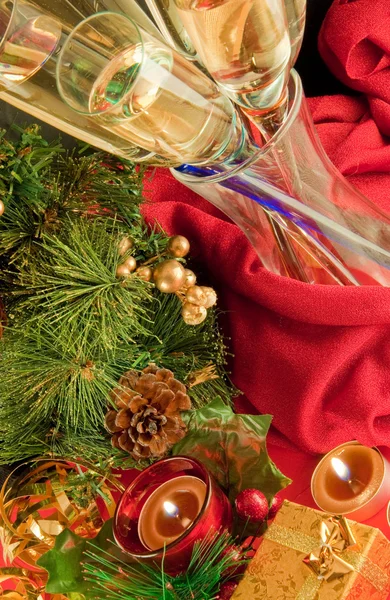Kartki świąteczne. szampan, oddział choinkowe i świeca na czerwonym tle — Zdjęcie stockowe