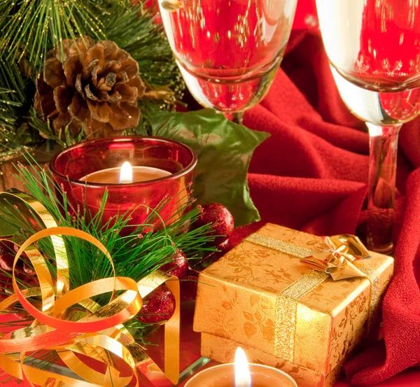Carte de Noël. Champagne, branche d'un sapin et bougie sur fond rouge — Photo