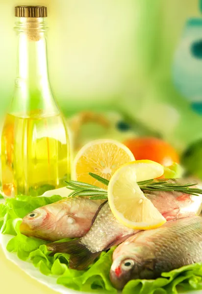 stock image Fresh fish, crucian with a lemon and an onions, salad with olive oil