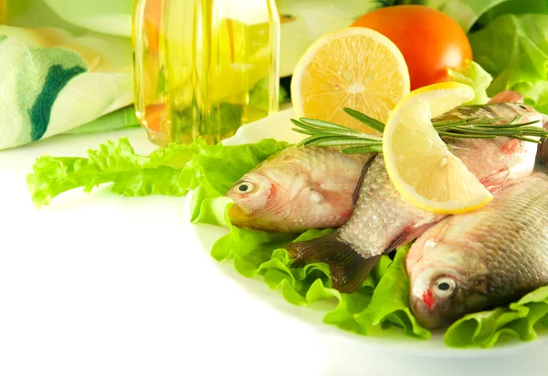 Verse vis, crucian met een citroen en een uien, salade met olijfolie — Stockfoto