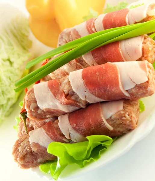 Rouleau de viande avec bacon, oignons et poivre, salade verte — Photo