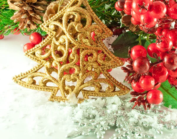 Рождественская ветвь ягод с золотой меховой ёлкой против снега — стоковое фото