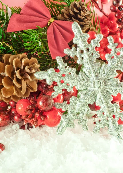 Weihnachtszweig von Beeren mit einer silbernen dekorativen Schneeflocke gegen Schnee — Stockfoto