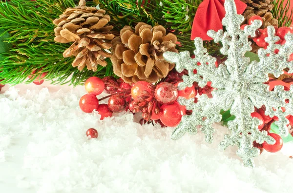 Jul gren av bären med en silver dekorativa snöflinga mot snö — Stockfoto
