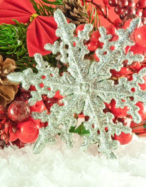 Ramo di Natale di bacche con un fiocco di neve decorativo d'argento contro neve — Foto Stock