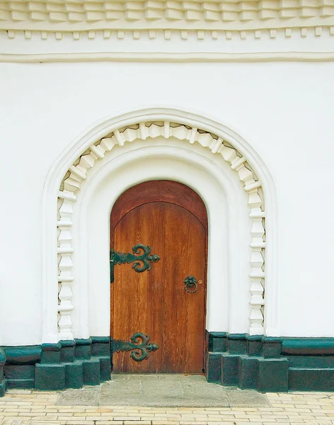 Αρχαία τα πόρτα σε ένα λευκό τοίχο ενός μοναστηριού — Φωτογραφία Αρχείου