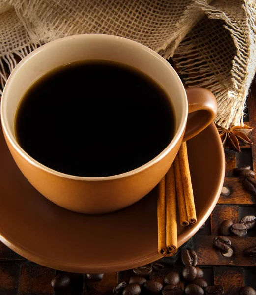 Tasse de café sur grange un fond, grains de café et cannelle — Photo