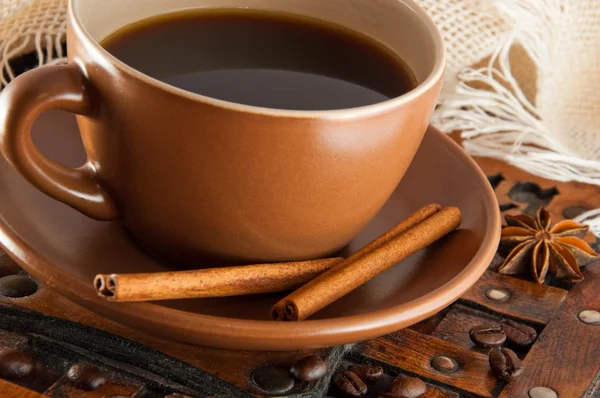 stock image Cup of coffee on grange a background, coffee grains and cinnamon