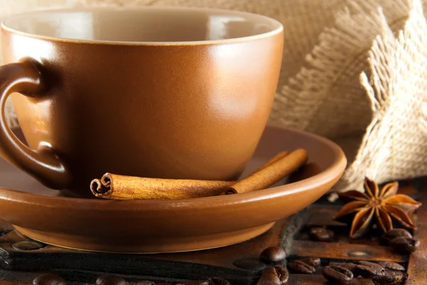 Cup of coffee on grange a background, coffee grains and cinnamon — Stock Photo, Image