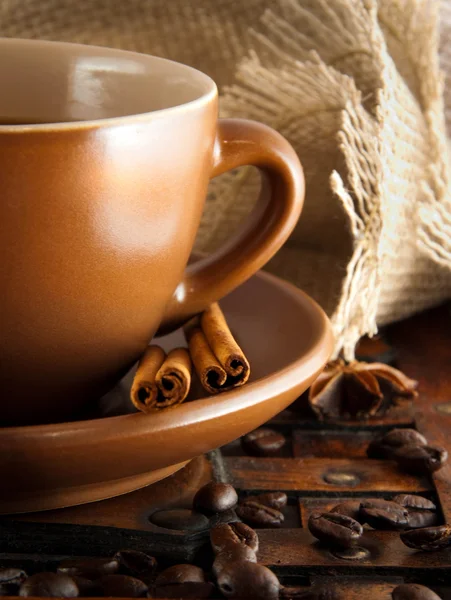 Filiżankę kawy na grange tło, ziaren kawy i cynamon — Zdjęcie stockowe