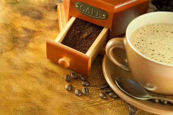 Moulin à café dans un style rétro, une tasse de café sur fond de grange — Photo