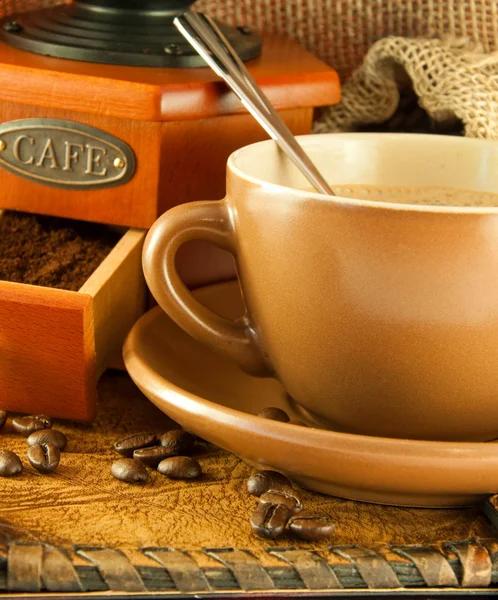 Macinino da caffè in stile retrò, una tazza di caffè su sfondo grange — Foto Stock