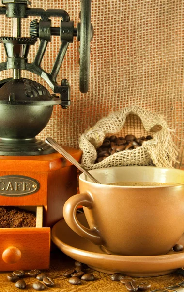 Coffee grinder in a retro style, a cup of coffee on grange background — Stock Photo, Image