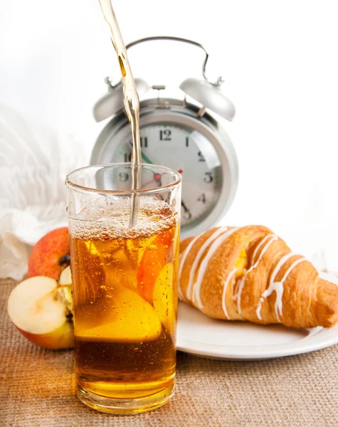 Juice, croissant and apple for a breakfast, an alarm clock — Stock Photo, Image