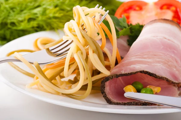 Cerdo hervido y espaguetis con tomates, guisantes y maíz — Foto de Stock