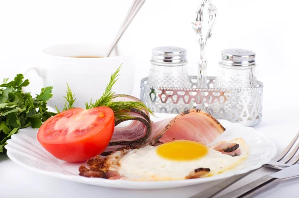 Fried eggs with bacon and tomatoes, a nourishing breakfast — Stock Photo, Image