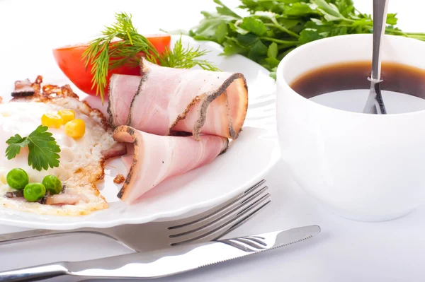 Sázená vejce se slaninou a rajčaty, hrášek a kukuřice, výživná snídaně — Stock fotografie