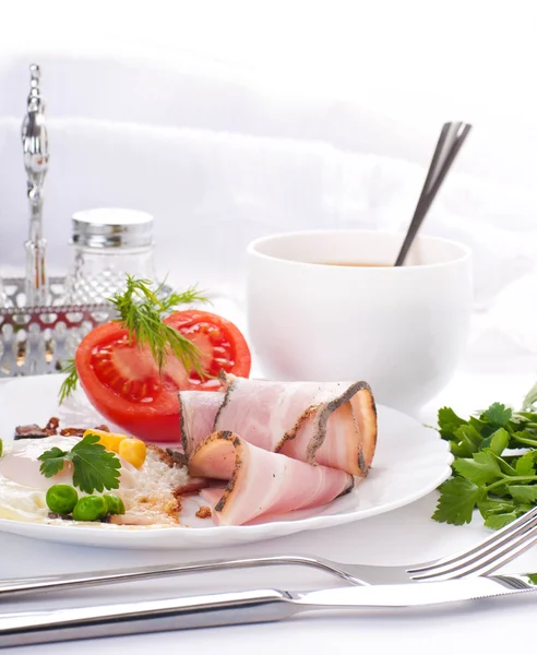Bacon med stekt ägg och tomater, en ärtor och majs, persilja och fänkål — Stockfoto