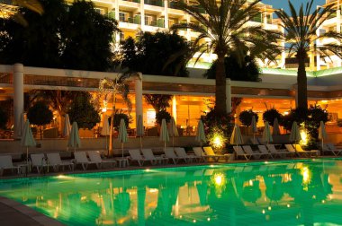 gece Yüzme Havuzu zemin, palmiye ağaçları ve otel karşı