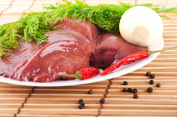 Fígado de porco com pimentão e uma cebola em uma tábua de bambu — Fotografia de Stock