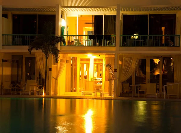 Piscina nocturna con el telón de fondo de palmeras y hoteles — Foto de Stock