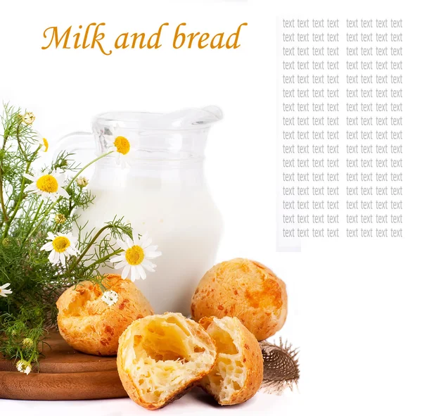 Кувшин с молоком, хлебом и дикими цветами на белом фоне — стоковое фото