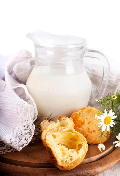 Konvice s mlékem, chléb a kytice na bílém pozadí — Stock fotografie