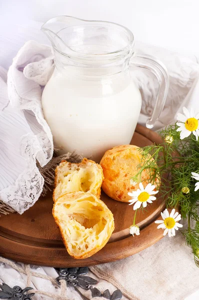 Krug mit Milch, Brot und Wildblumen auf weißem Hintergrund — Stockfoto