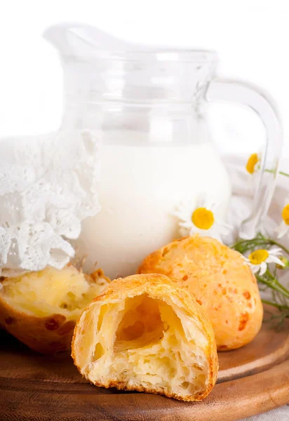 Krug mit Milch, Brot und Wildblumen auf weißem Hintergrund — Stockfoto