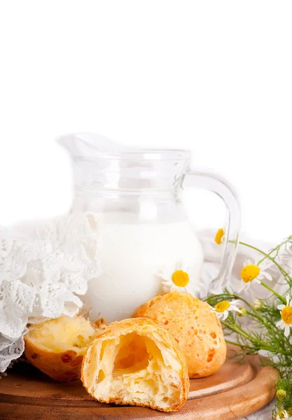 Jug with milk, bread and wild flowers on a white background — Stock Photo, Image