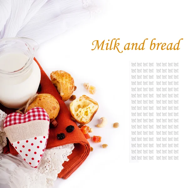 Caraffa con latte, pane e cuore rosso su sfondo bianco — Foto Stock
