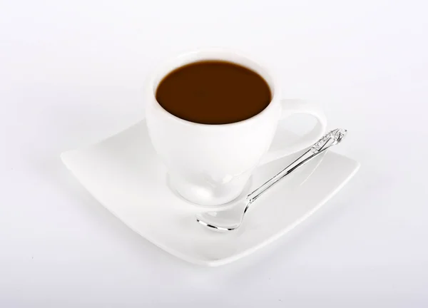 White cup of coffee with a silver spoon on a white background — Stock Photo, Image