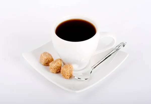 White cup of coffee with a silver spoon and brown sugar on a white background — Stock Photo, Image