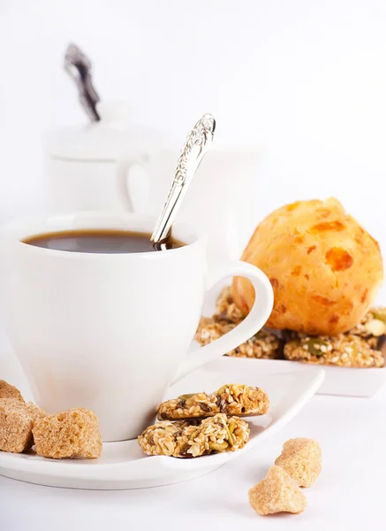 Xícara branca de café com uma colher de prata e açúcar mascavo em um fundo branco — Fotografia de Stock