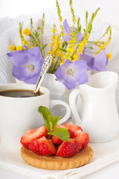 Jahody s mátou a šálek kávy, letní květiny — Stock fotografie
