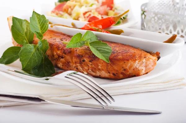 A salmon is fried with a basil and tomato — Stock Photo, Image
