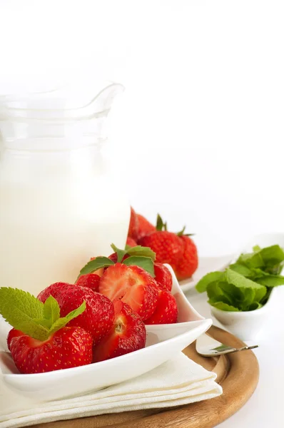 草莓与薄荷和水罐的牛奶在一块白色餐巾来。 — 图库照片