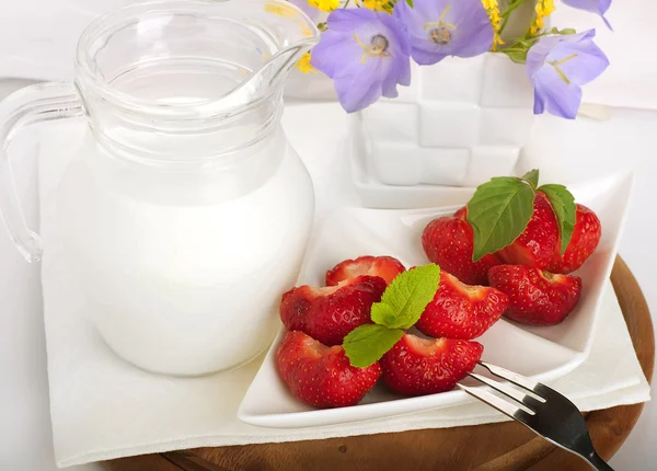 草莓与薄荷和水罐的牛奶在一块白色餐巾来。 — 图库照片