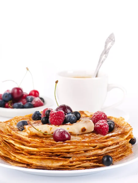 Pannenkoeken met bessen en kopje koffie op een witte achtergrond — Stockfoto