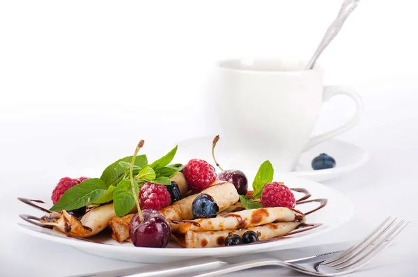 Pandekager med bær og mynte og kop kaffe på hvid baggrund - Stock-foto
