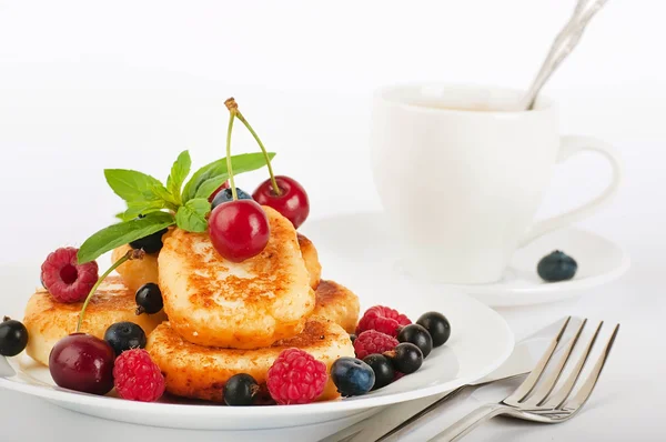 Сырные блинчики с лесными ягодами и чашечкой кофе — стоковое фото