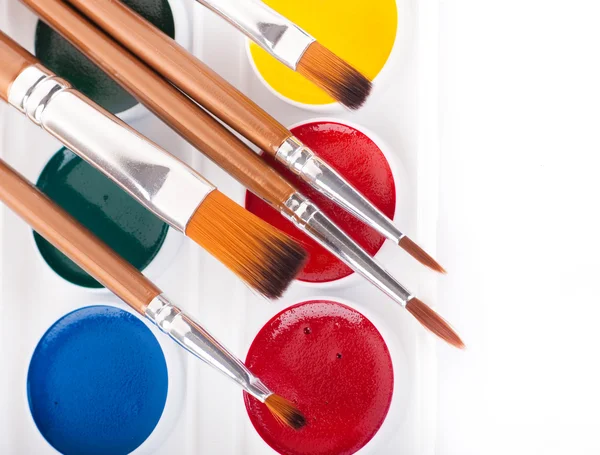 Tužky, barvy a štětce na bílém pozadí — Stock fotografie