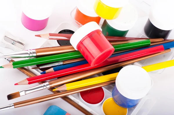 Tužky, barvy a štětce na bílém pozadí — Stock fotografie