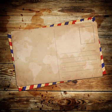 Vintage postcard with envelop on wooden background clipart