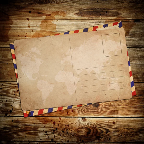 Vintage postcard with envelop on wooden background — Stock Photo, Image